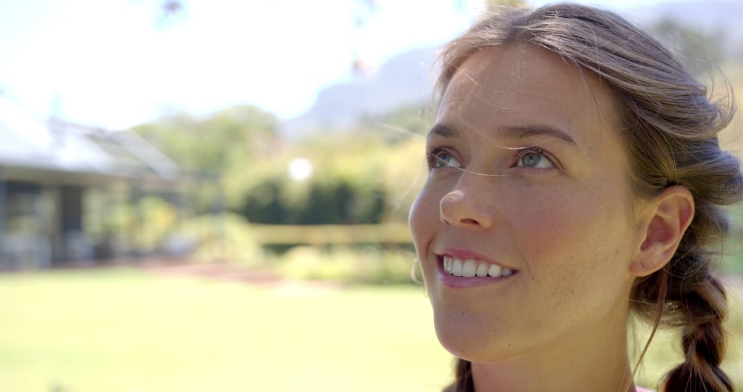 Smiling Woman Enjoying Sunny Day in Serene Garden