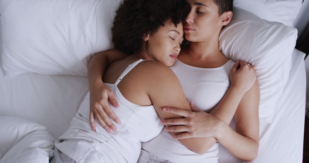 Interracial Lesbian Couple Embracing in Bed Wearing White Shirts - Free Images, Stock Photos and Pictures on Pikwizard.com