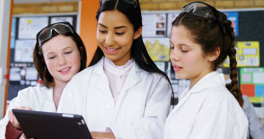 Teen Girls Collaborating in Science Class with Tablet