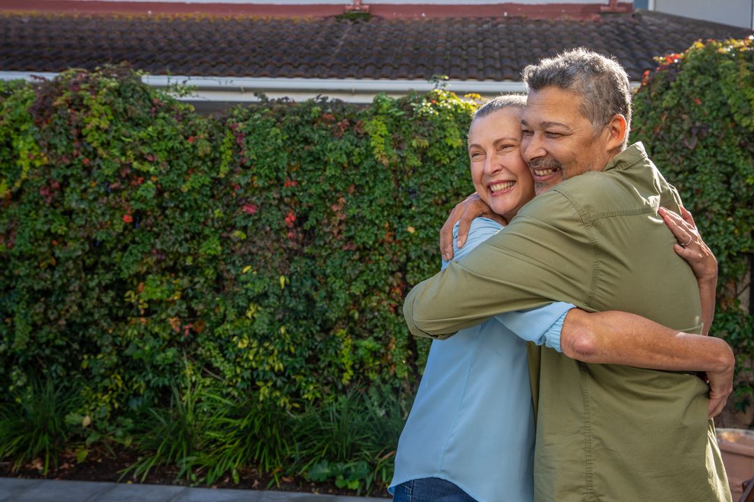 Senior Couple Embracing in Garden Nearby Lush Foliage