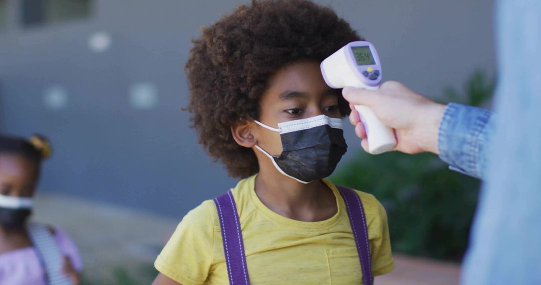 Child Undergoing Temperature Check at School Entrance for Safety