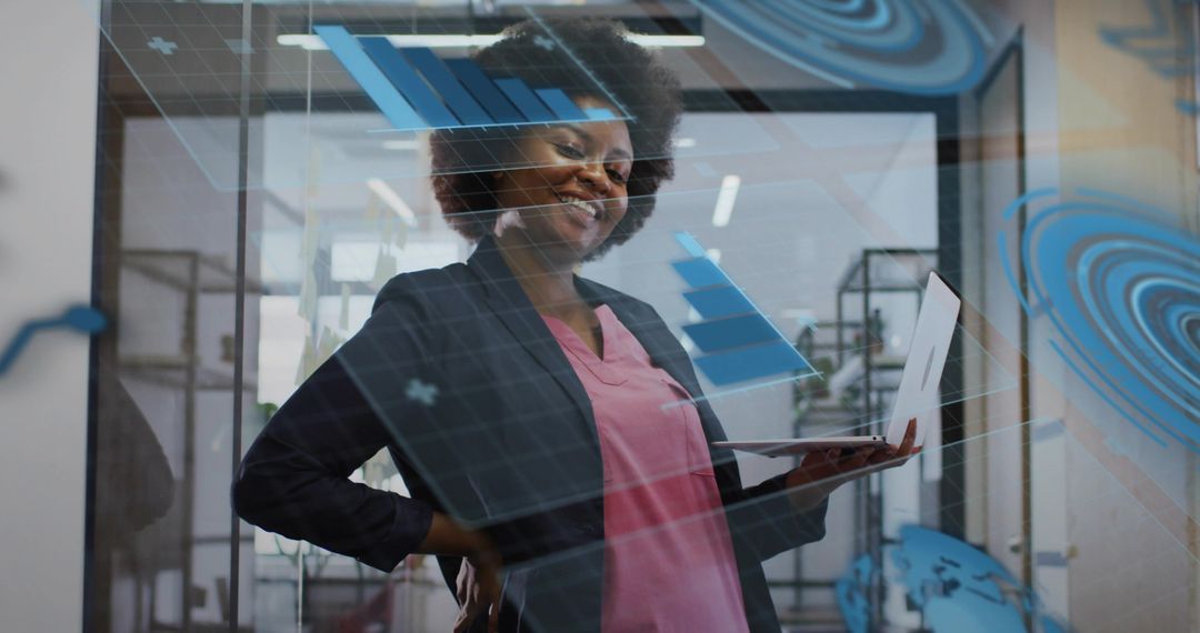 Confident professional holding laptop analyzing interactive data visualizations on glass