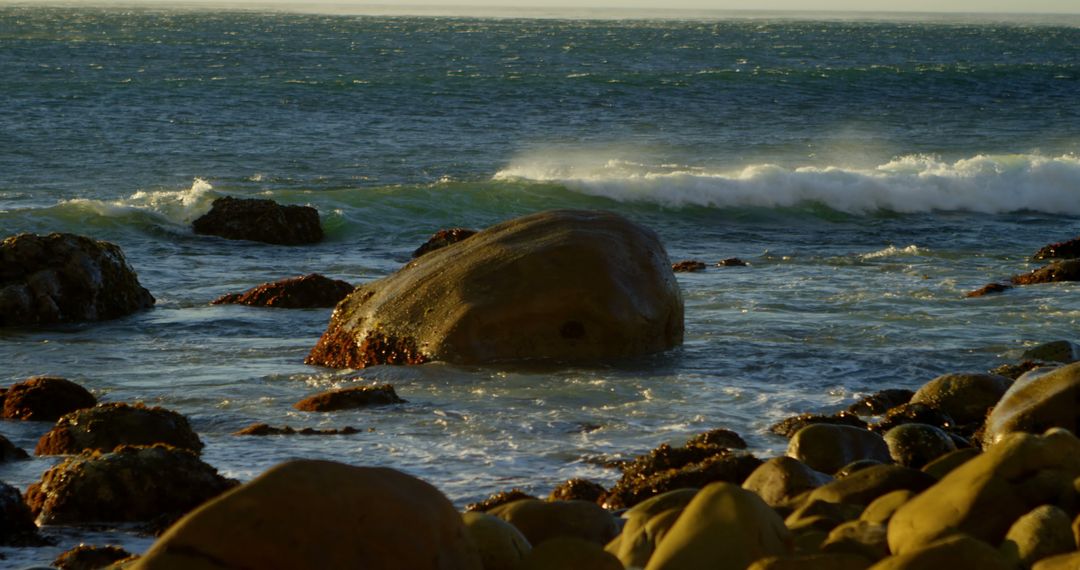 Waves Crashing on Rocky Seashore at Sunset - Free Images, Stock Photos and Pictures on Pikwizard.com