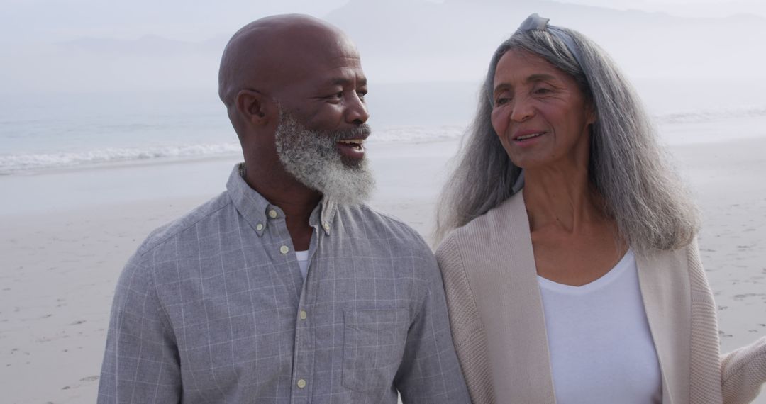 Senior Couple Smiling and Walking on Beach - Free Images, Stock Photos and Pictures on Pikwizard.com