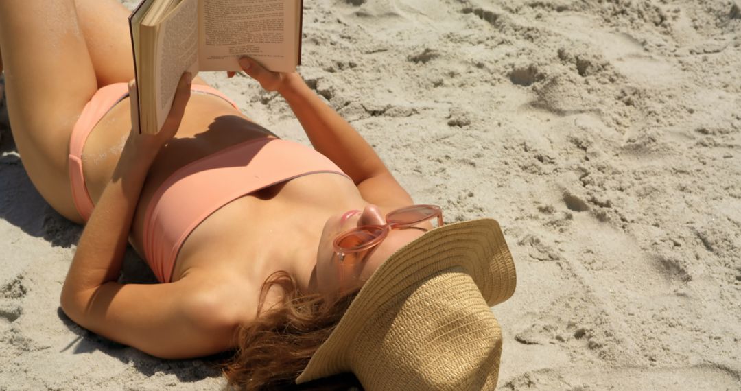 Woman in Bikini Reclining on Beach with Book