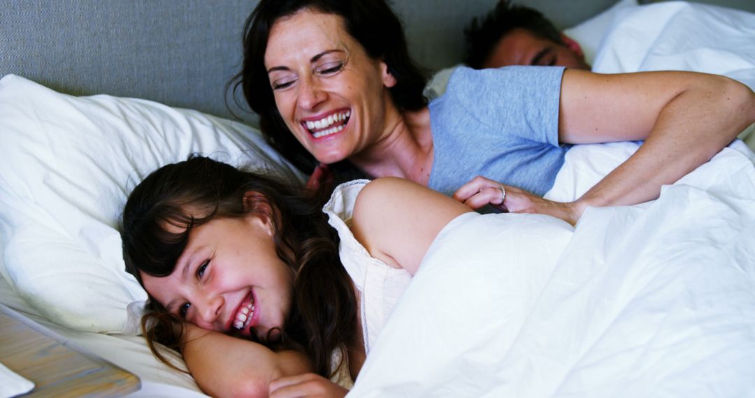 Smiling Family Cuddling in Bed During Morning - Free Images, Stock Photos and Pictures on Pikwizard.com