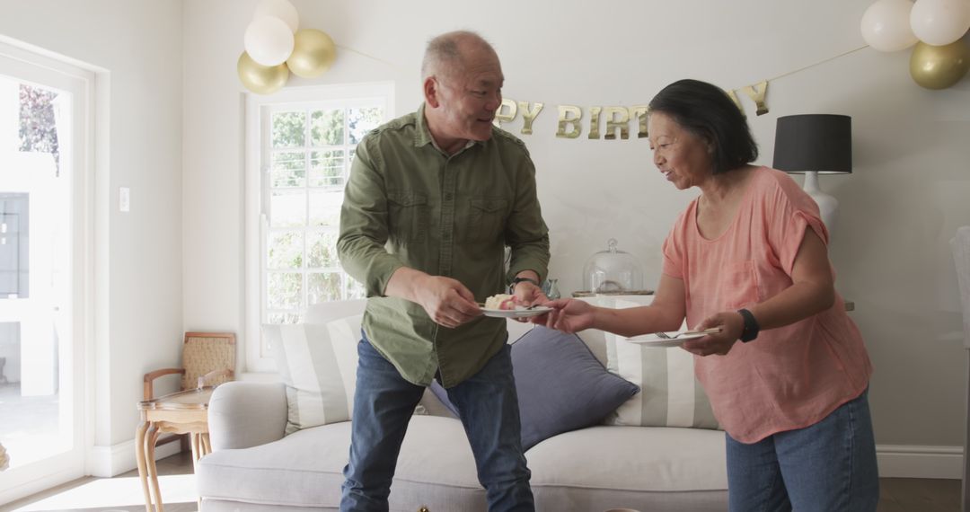 Senior Couple Joyfully Dancing During Birthday Party at Home