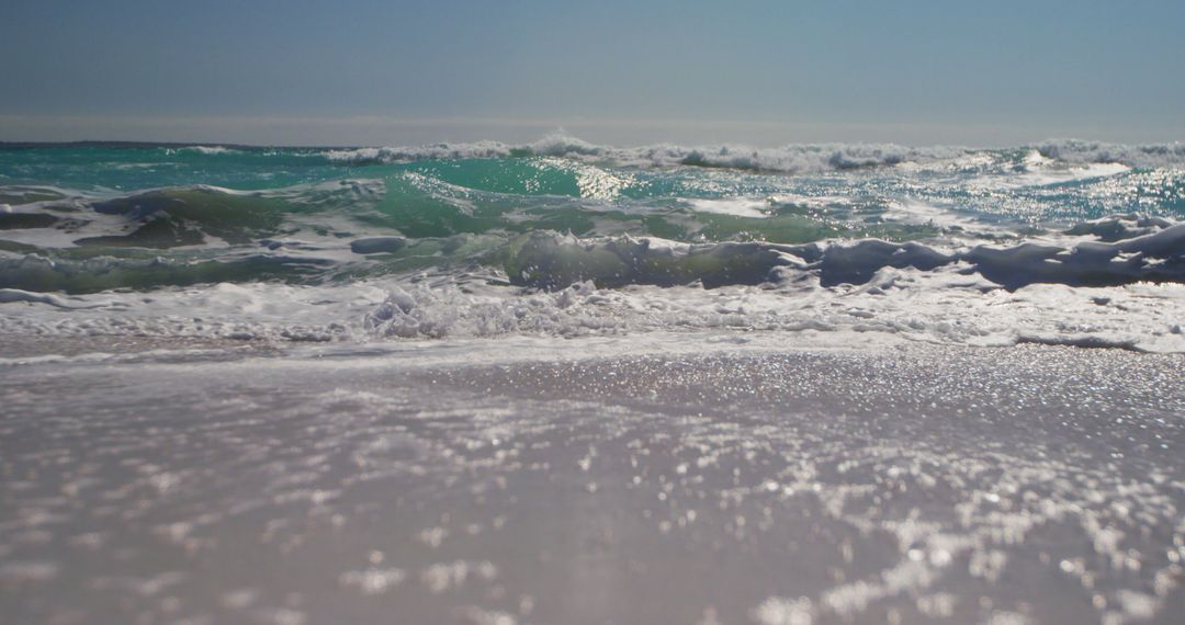 Waves Crashing on Sandy Beach Under Bright Sunlight - Free Images, Stock Photos and Pictures on Pikwizard.com