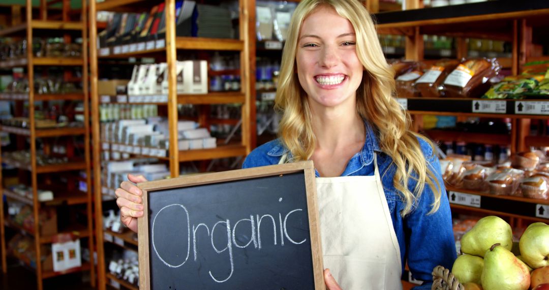 Smiling Woman Holding Organic Sign in Grocery Store - Free Images, Stock Photos and Pictures on Pikwizard.com