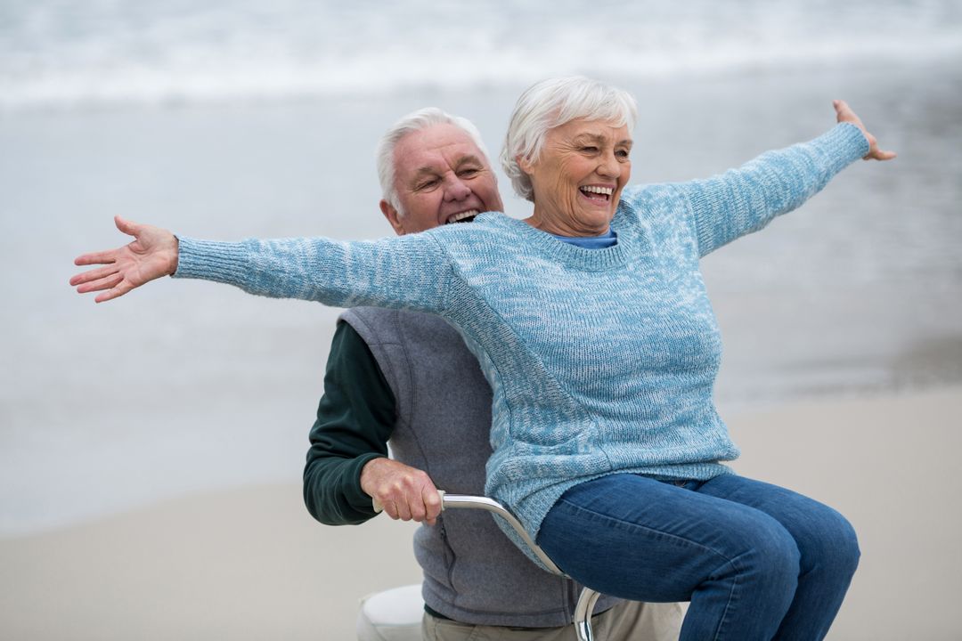 Senior couple riding bicycle on the beach - Free Images, Stock Photos and Pictures on Pikwizard.com