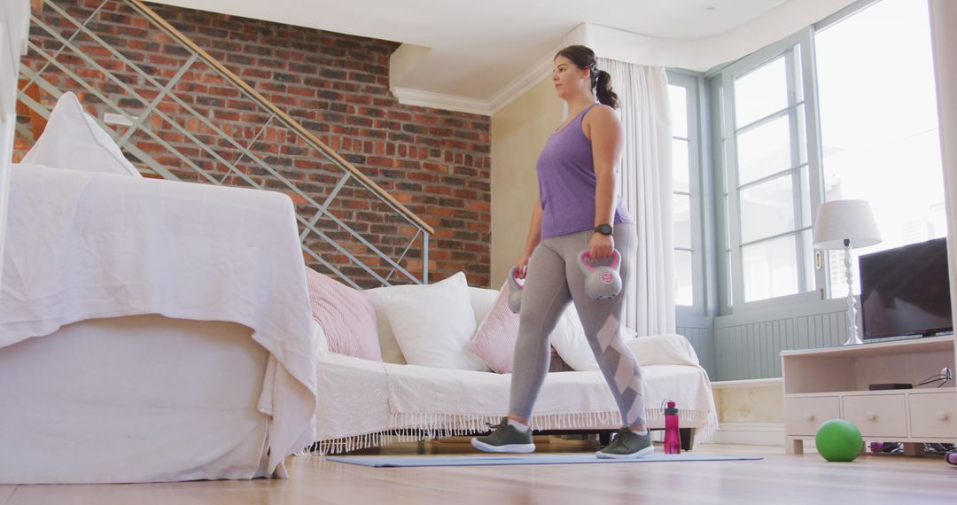 Woman Exercising Indoors with Dumbbells at Home - Free Images, Stock Photos and Pictures on Pikwizard.com