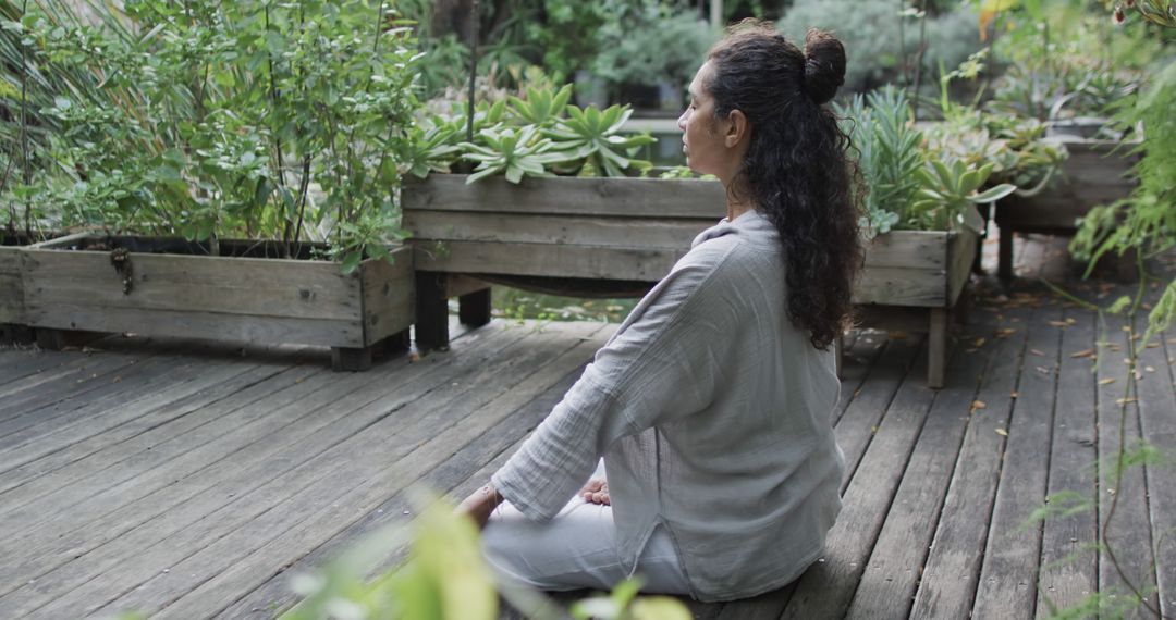 Woman meditating outdoors on serene wooden deck - Free Images, Stock Photos and Pictures on Pikwizard.com