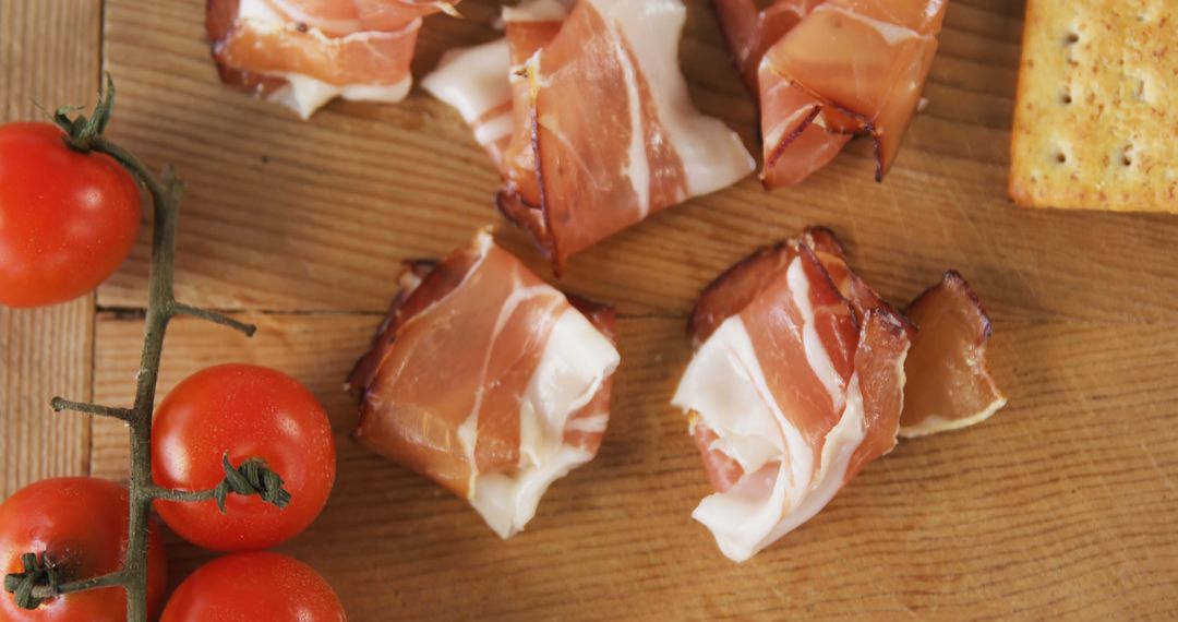 Assorted Ham, Tomatoes and Crackers on Wooden Board - Free Images, Stock Photos and Pictures on Pikwizard.com