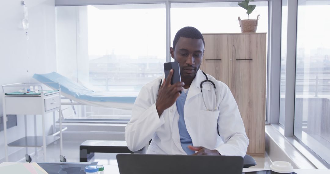 African American Doctor Video Calling While Working in Modern Medical Office - Free Images, Stock Photos and Pictures on Pikwizard.com