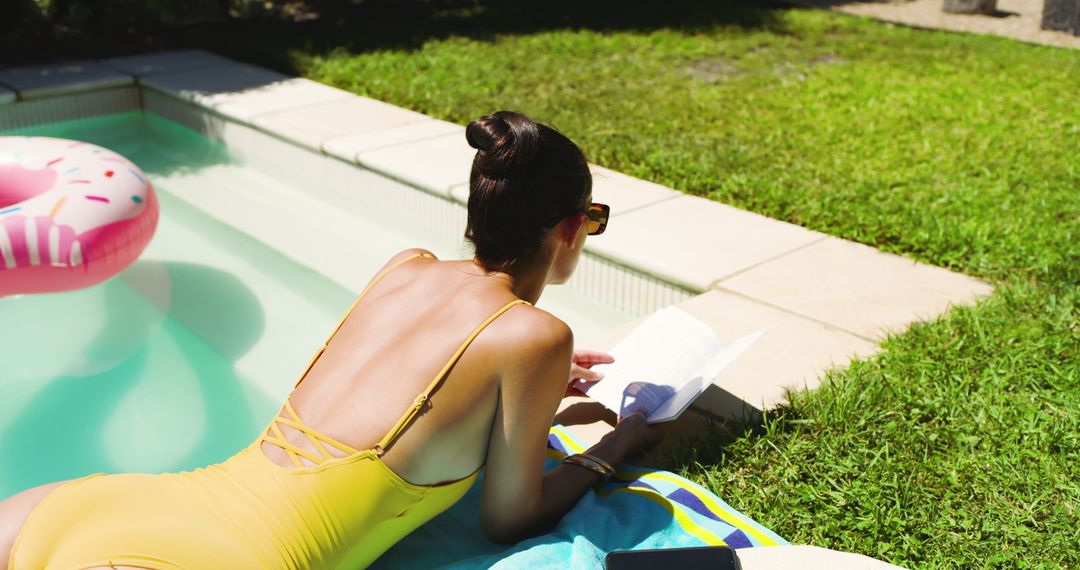 Woman Enjoying Leisure at Poolside Reading Book in Sunshine