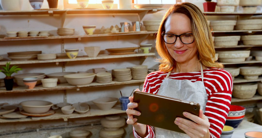 Smiling Female Potter with Tablet in Ceramic Workshop - Free Images, Stock Photos and Pictures on Pikwizard.com