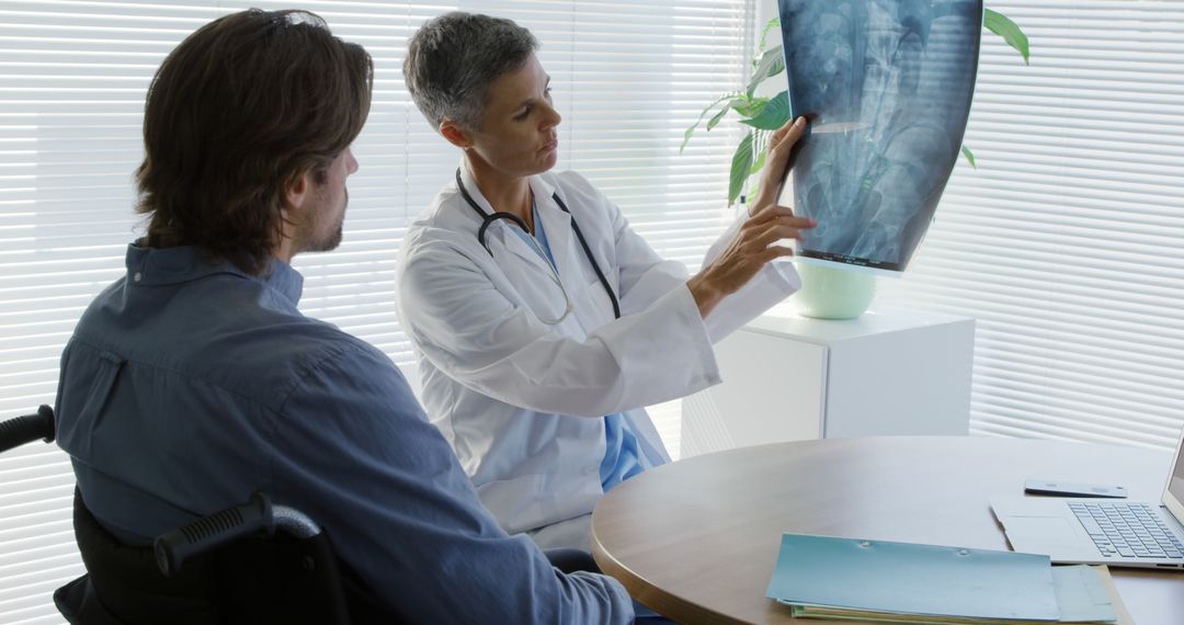 Doctor Discussing Spinal X-Ray with Patient in Wheelchair - Free Images, Stock Photos and Pictures on Pikwizard.com