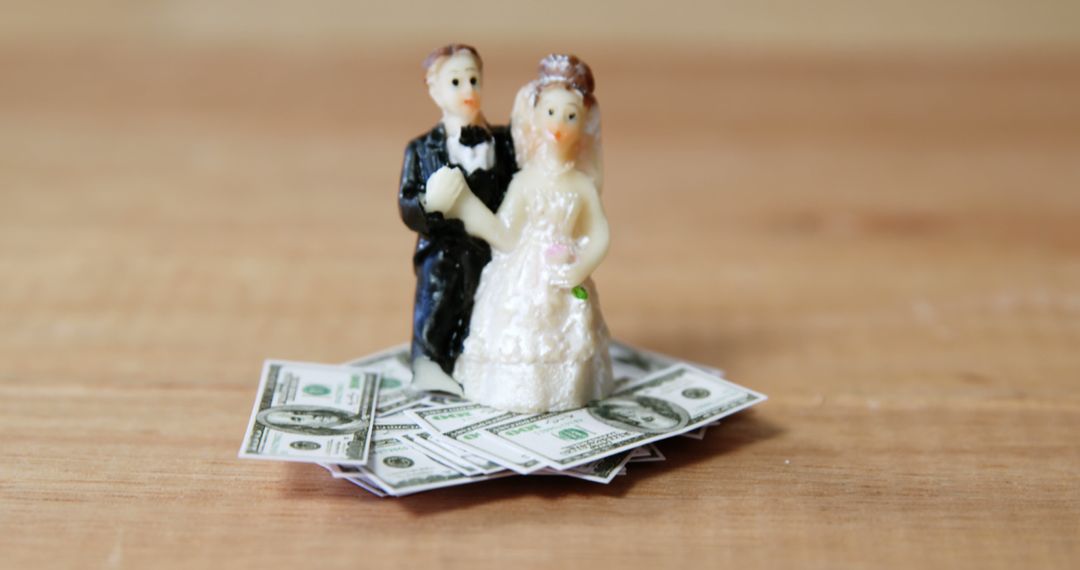 Bride and Groom Figurines Standing on a Pile of Dollar Bills - Free Images, Stock Photos and Pictures on Pikwizard.com