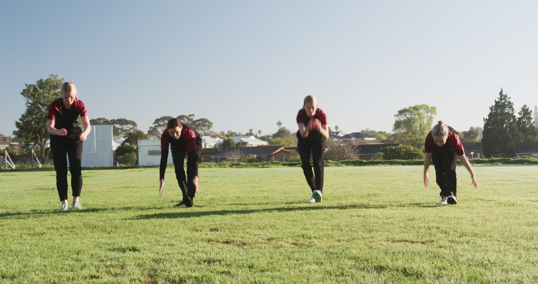 Team of Fitness Enthusiasts Training Together on Green Field