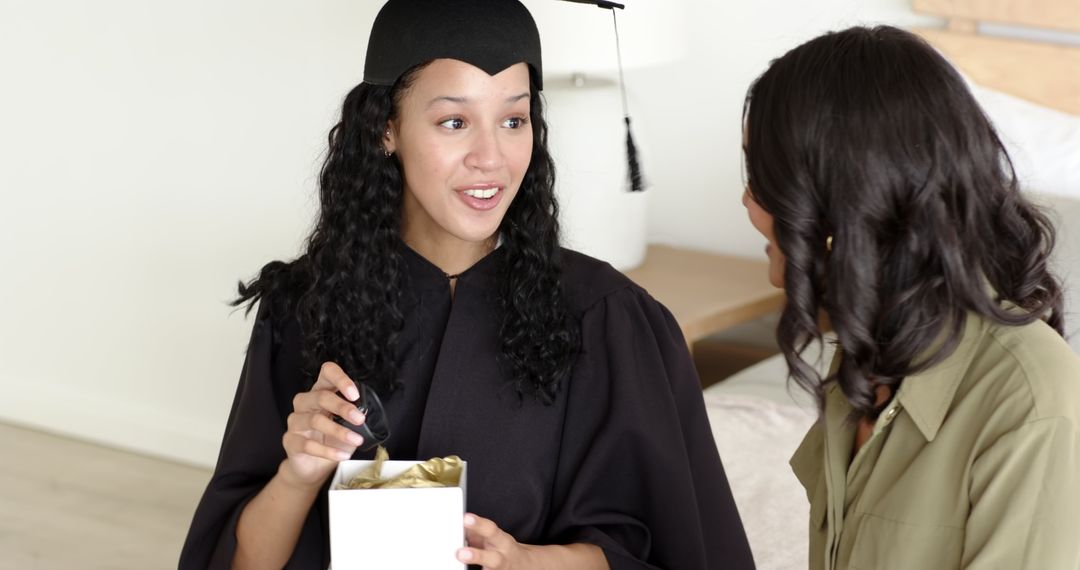 Graduate in Cap and Gown Sharing Moment with Close Friend