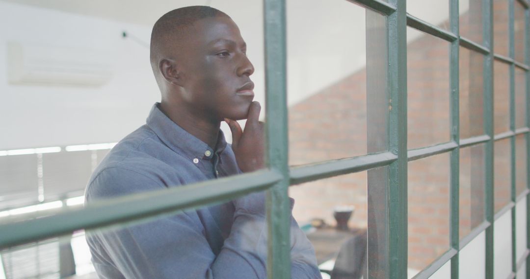 Pensive Businessman Looking through Office Window