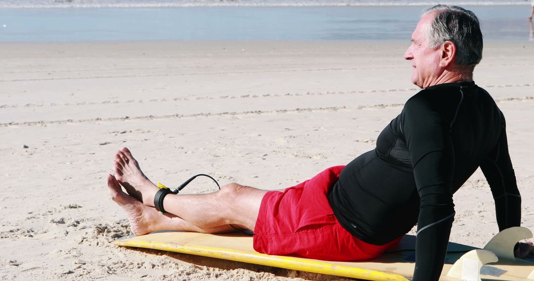 Senior Man Resting on Beach with Surfboard in the Sun - Free Images, Stock Photos and Pictures on Pikwizard.com