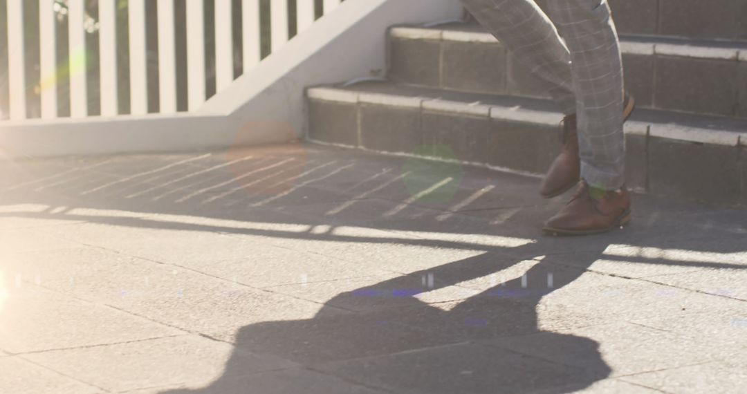 Businessman Walking Down Steps with Shadow and Lens Flare