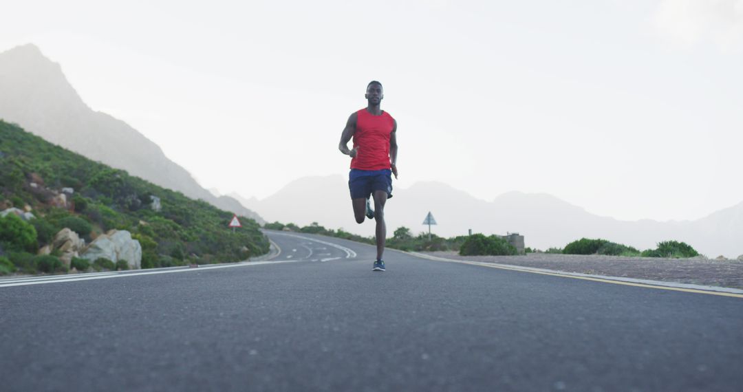 Young Fit Man Running on Empty Road in Mountain Landscape - Free Images, Stock Photos and Pictures on Pikwizard.com