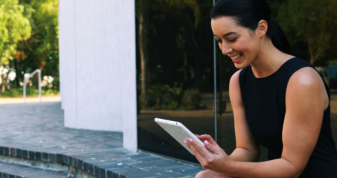 Professional Woman Smiling While Using Tablet Outdoors - Free Images, Stock Photos and Pictures on Pikwizard.com