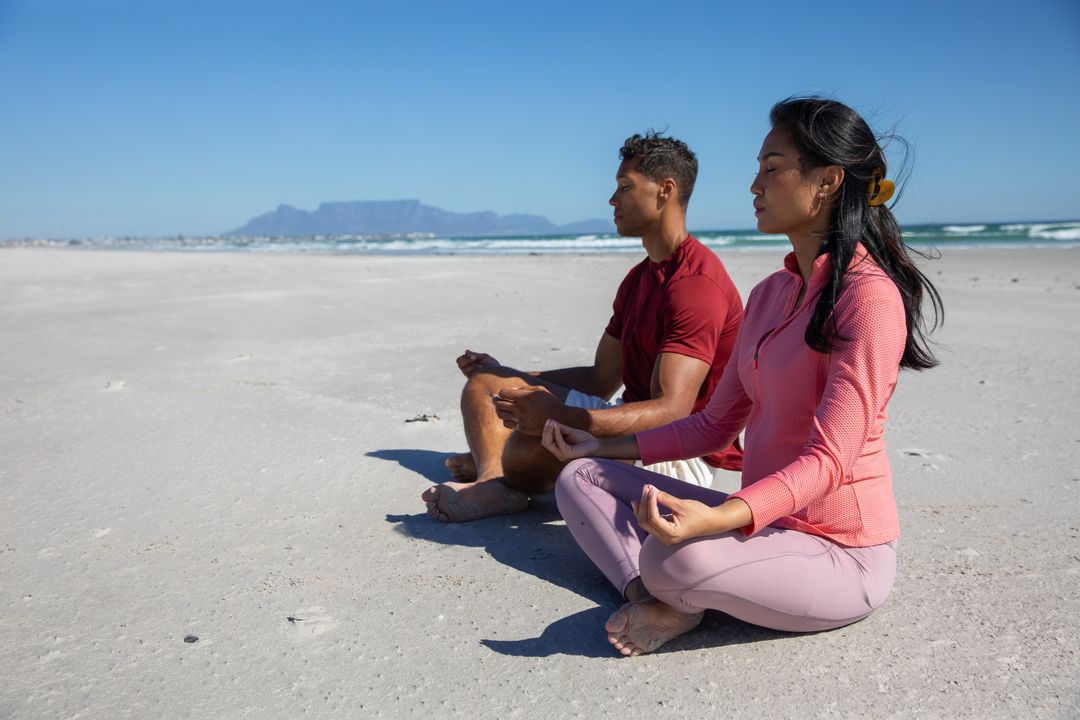 Diverse Couple Meditating on Serene Sandy Beachfront