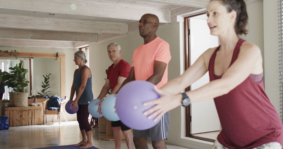 Diverse Group Practicing Pilates with Exercise Balls in Bright Studio - Free Images, Stock Photos and Pictures on Pikwizard.com