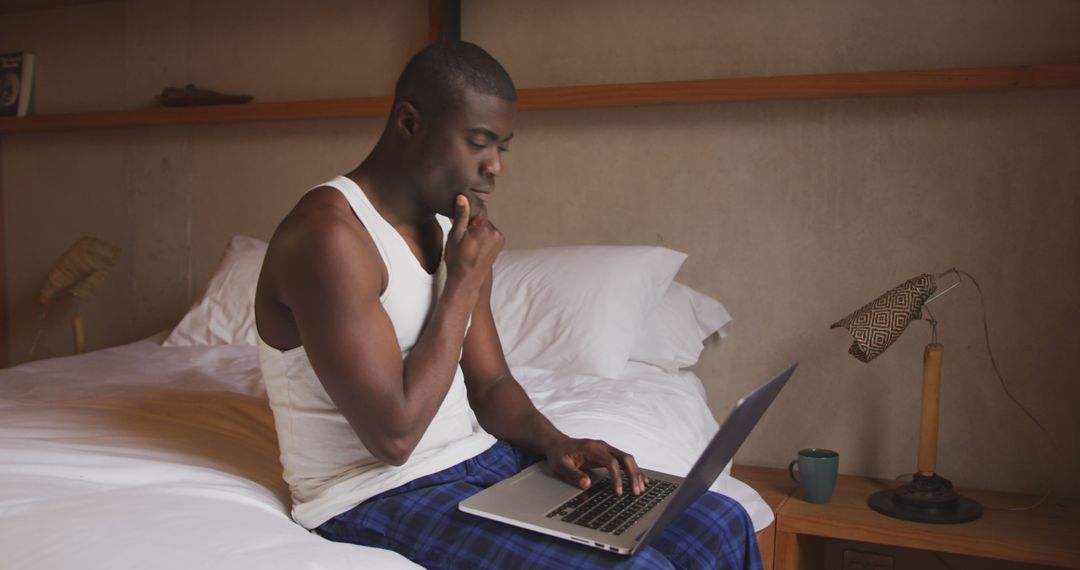 Man Concentrating While Working on Laptop in Bed - Free Images, Stock Photos and Pictures on Pikwizard.com