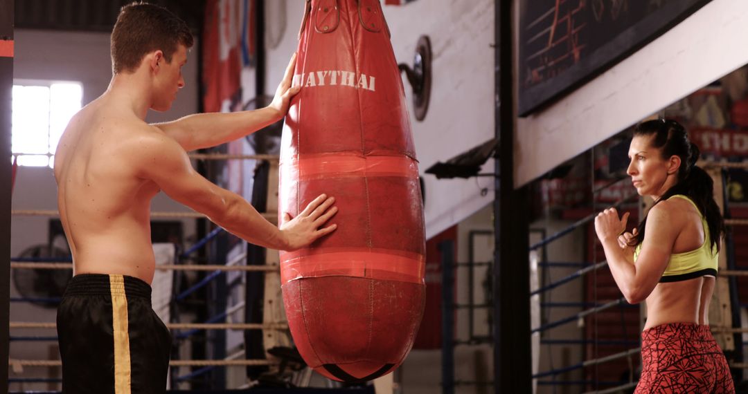 Instructors and Students Training with Punching Bag at Muay Thai Gym - Free Images, Stock Photos and Pictures on Pikwizard.com