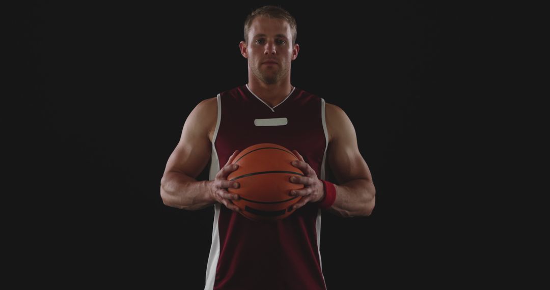 Focused Basketball Player in Maroon Jersey Holding Ball - Free Images, Stock Photos and Pictures on Pikwizard.com