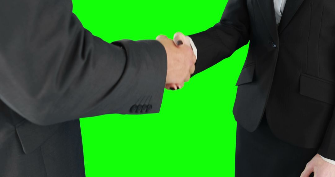 Business Handshake Symbolizing Agreement over Green Background