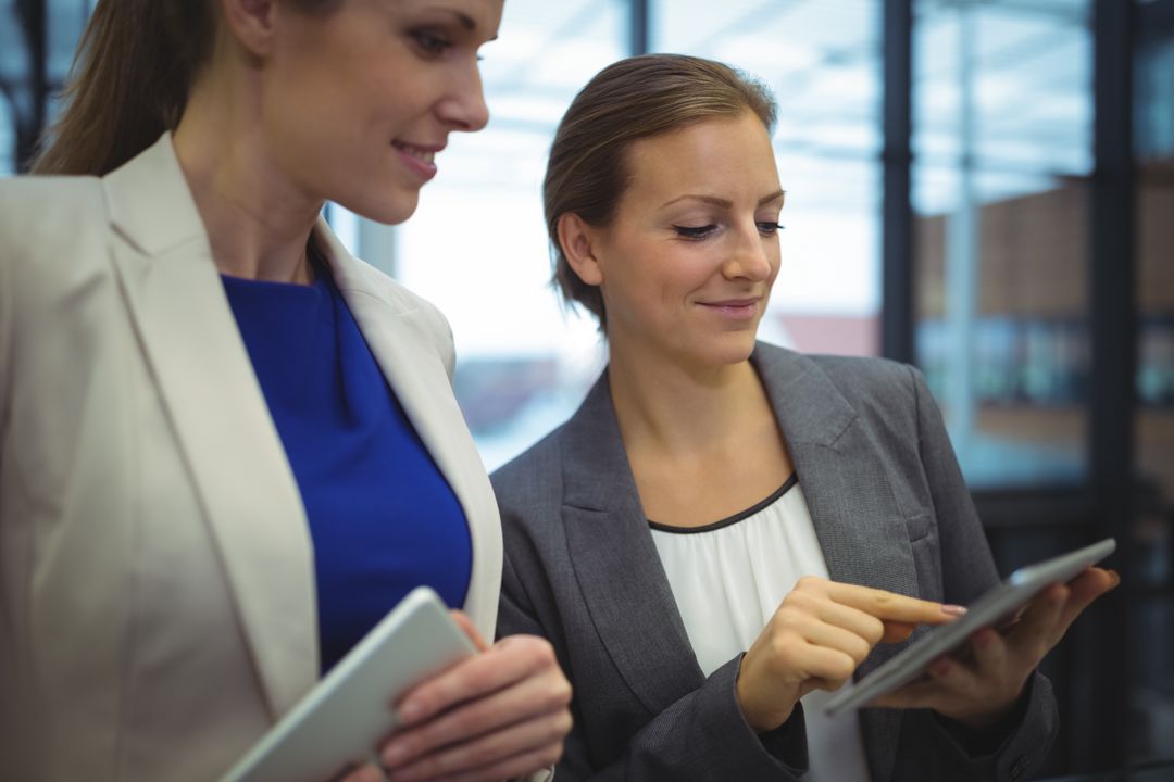 Business Executives Collaborating on Tablet in Modern Office