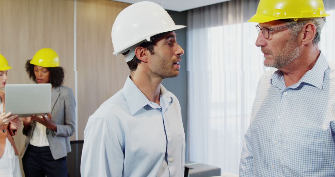 Business Meeting Between Engineers Wearing Safety Helmets - Free Images, Stock Photos and Pictures on Pikwizard.com