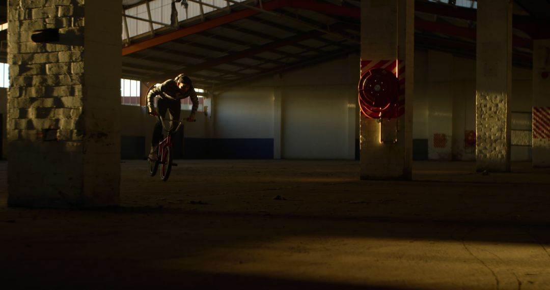 BMX Rider Performing Tricks in Abandoned Warehouse - Free Images, Stock Photos and Pictures on Pikwizard.com