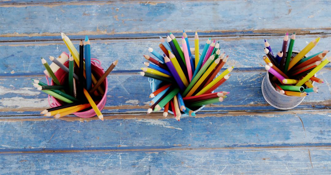 Colorful Pencils in Containers on Weathered Wooden Table - Free Images, Stock Photos and Pictures on Pikwizard.com