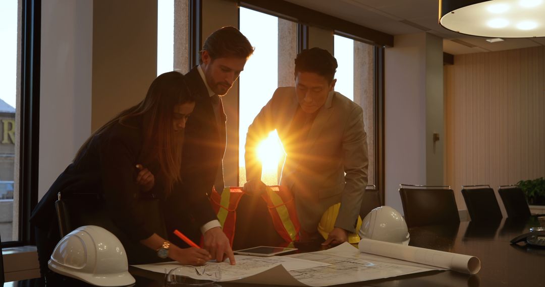 Architects Reviewing Plans in Office Setting at Sunset - Free Images, Stock Photos and Pictures on Pikwizard.com