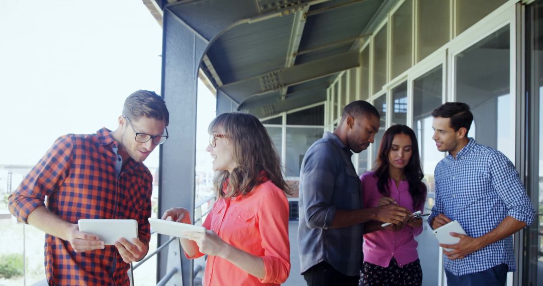 Diverse Professionals Collaborating with Technology on Modern Balcony