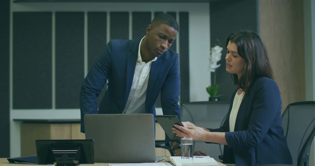 Coworkers Collaborating on Tablet in Modern Office Environment