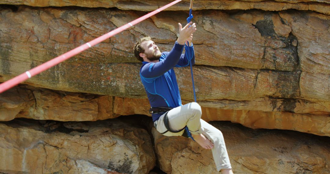 Man Climbing Rope Hanging from Cliff Outdoor Adventure - Free Images, Stock Photos and Pictures on Pikwizard.com