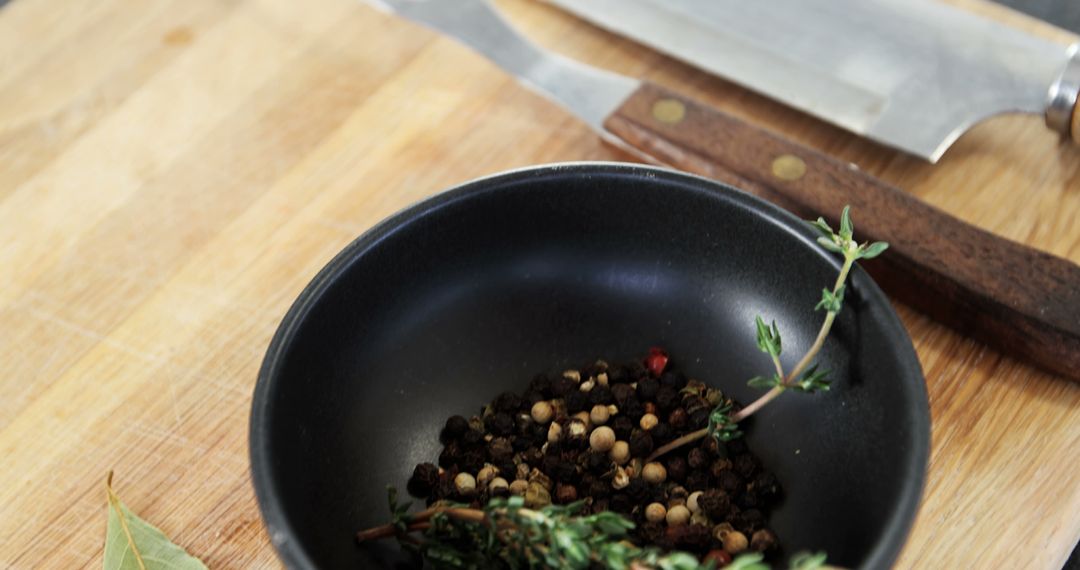 Assortment of Peppercorns and Herbs in Black Bowl on Wooden Cutting Board - Free Images, Stock Photos and Pictures on Pikwizard.com