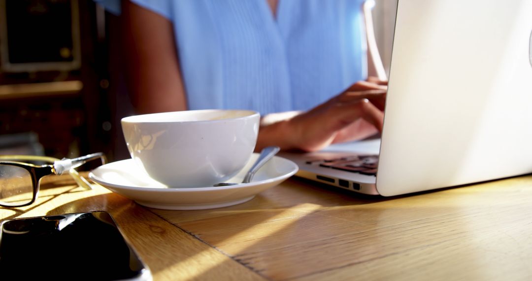 Businesswoman Working on Laptop in Sunny Cafe
