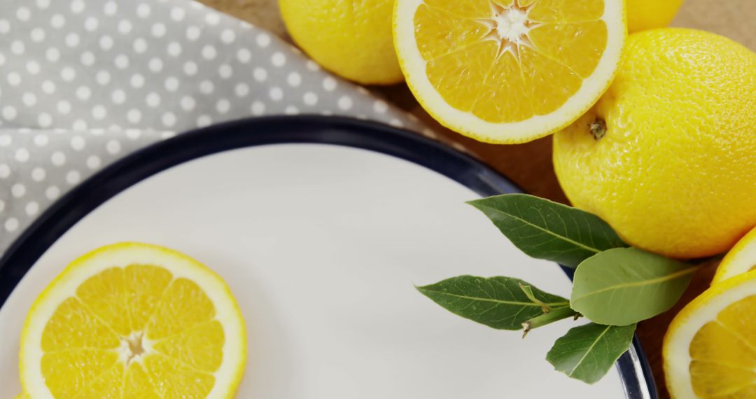 Fresh Lemons on Dotted Fabric with Green Leaves and Plate