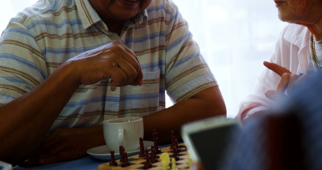 Elderly Individuals Engaging in Game of Chess Over Coffee - Free Images, Stock Photos and Pictures on Pikwizard.com