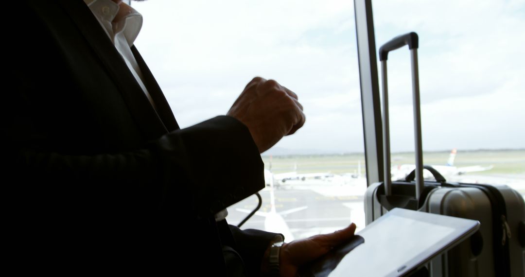 Businessman at Airport with Digital Tablet Handling Work Challenges