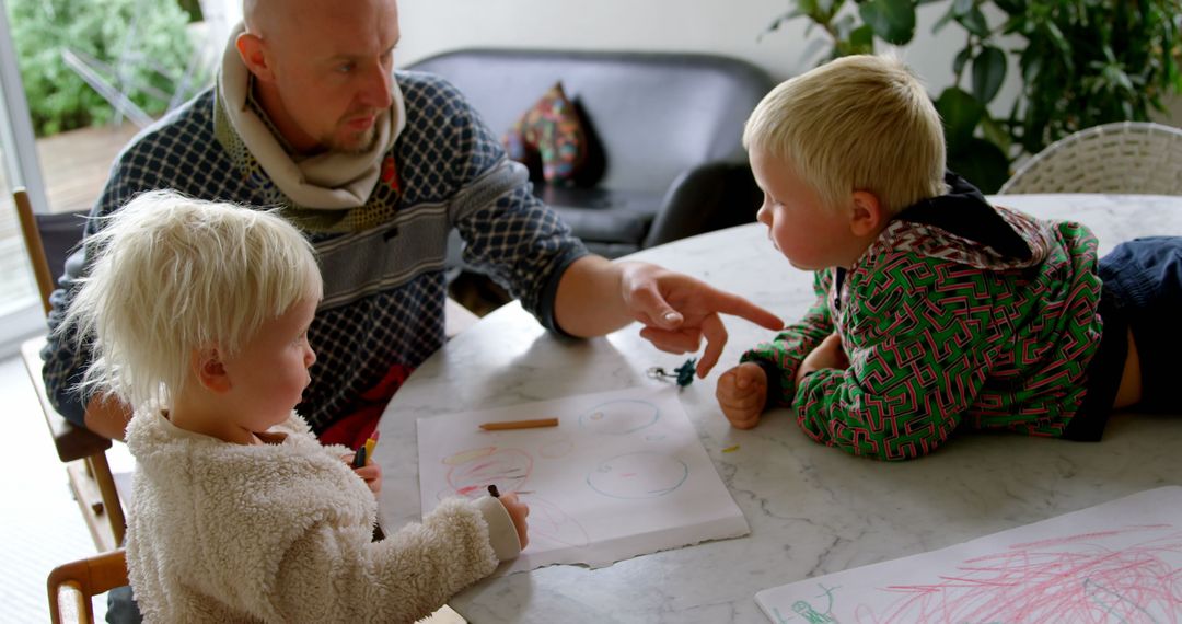 Father Assisting Children with Drawing at Home