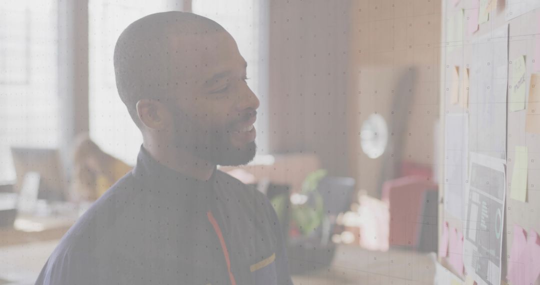 Professional Reviewing Office Plans on Brick Wall with Sticky Notes